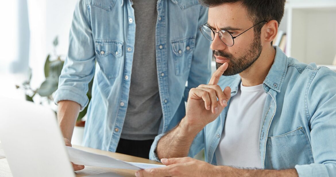 two-successful-stylish-man-financiers-analyze-business-documents-work-new-startup-project